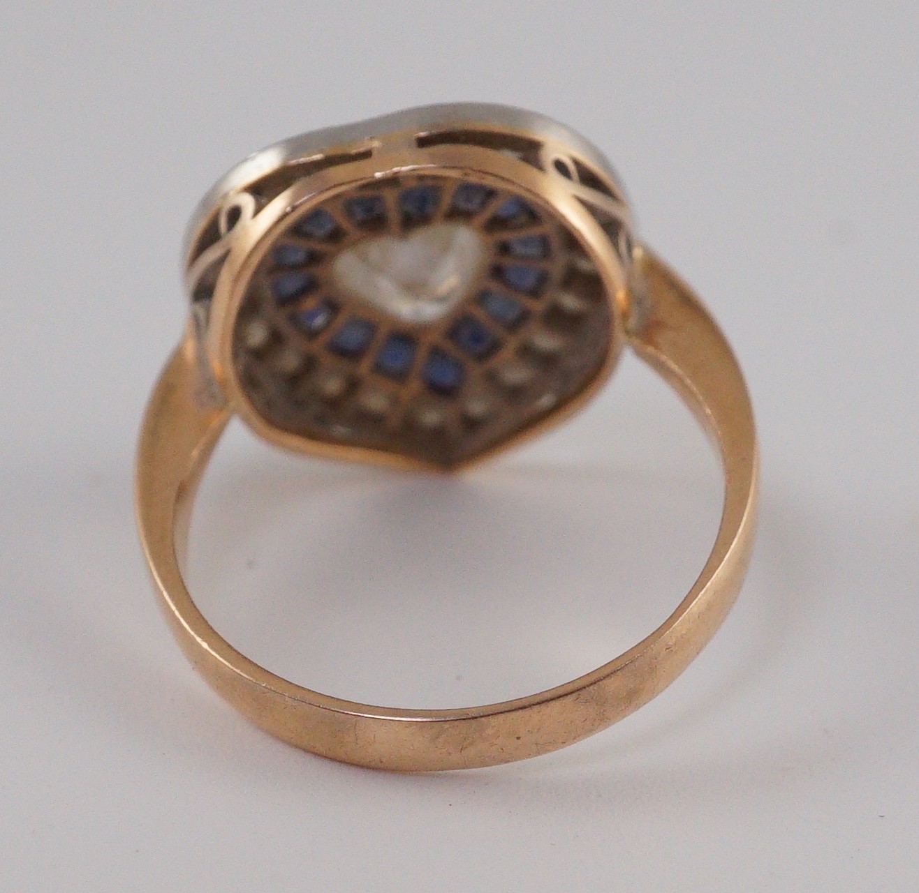 A 1920's, gold and platinum, millegrain set sapphire and diamond cluster set ring, with central heart shaped diamond